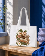 Bolsa tote blanca con la pila de libros, la manzana de leopardo y las flores estampadas