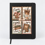 Libreta negra de tapa dura con cuatro estampillas: manzana de leopardo, café, libros y cuaderno, con las palabras Enseña, Ama e Inspira