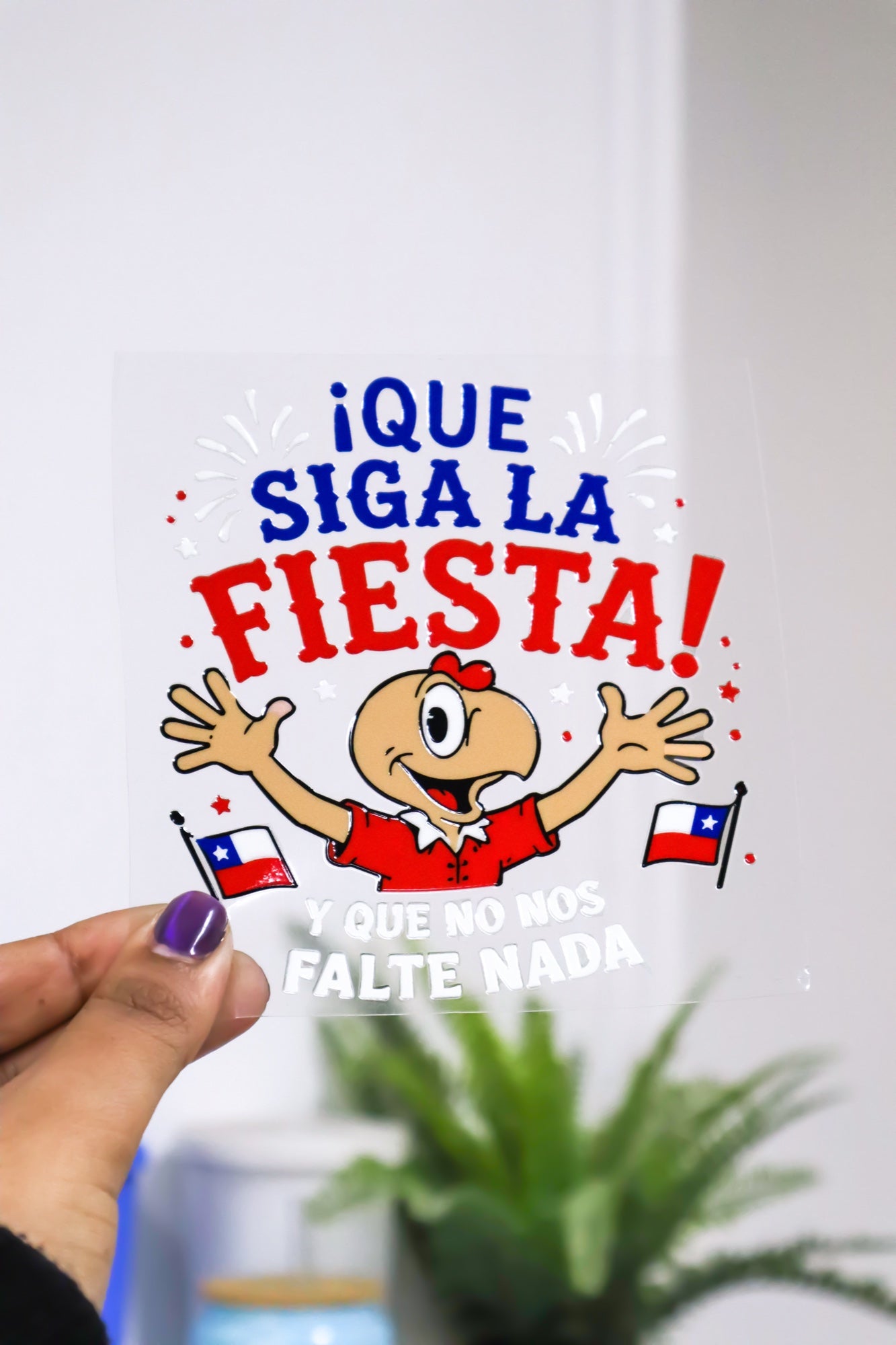 Diseño recortado Que siga la fiesta, sostenido en la mano