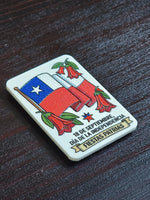 Detalle en ángulo del imán de bandera y copihues, donde se ve el relieve