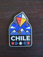 Imán de volantín tricolor entre montañas con la palabra Chile