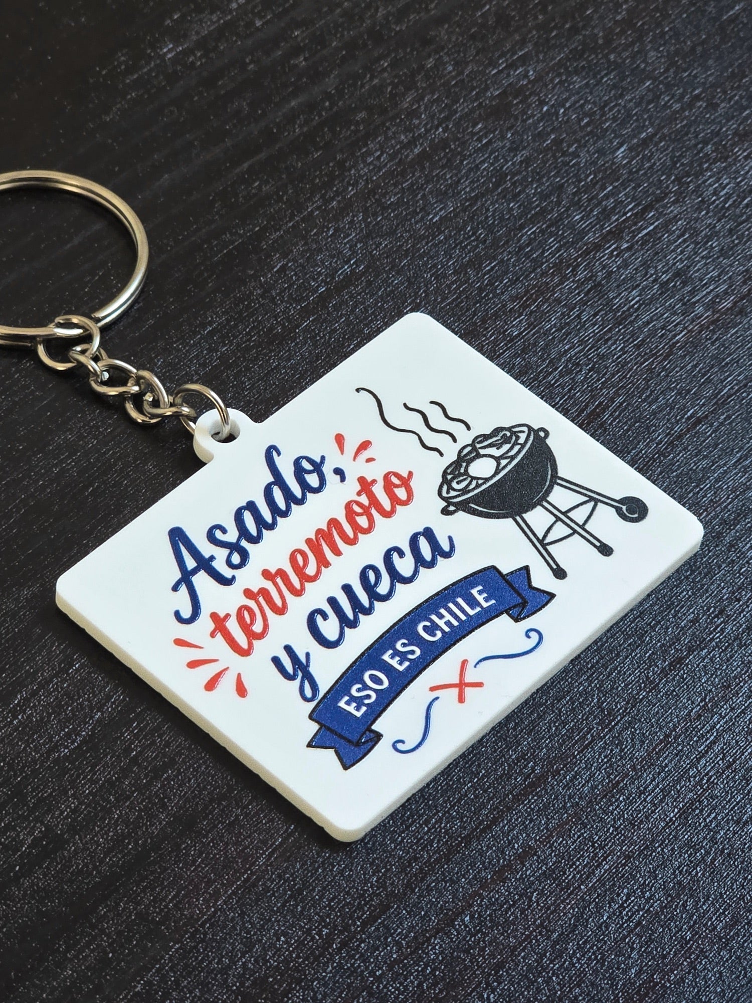 Llavero cuadrado con la frase Asado, terremoto y cueca, eso es Chile