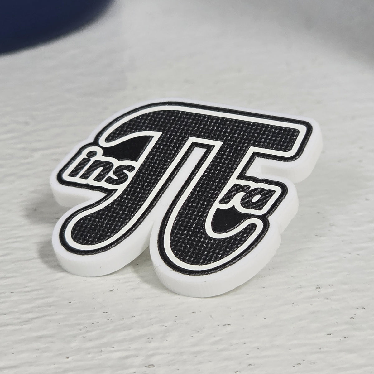 Pin con la palabra Inspira en letras grandes, fondo blanco