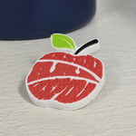 Pin de manzana roja con hoja verde, fondo blanco