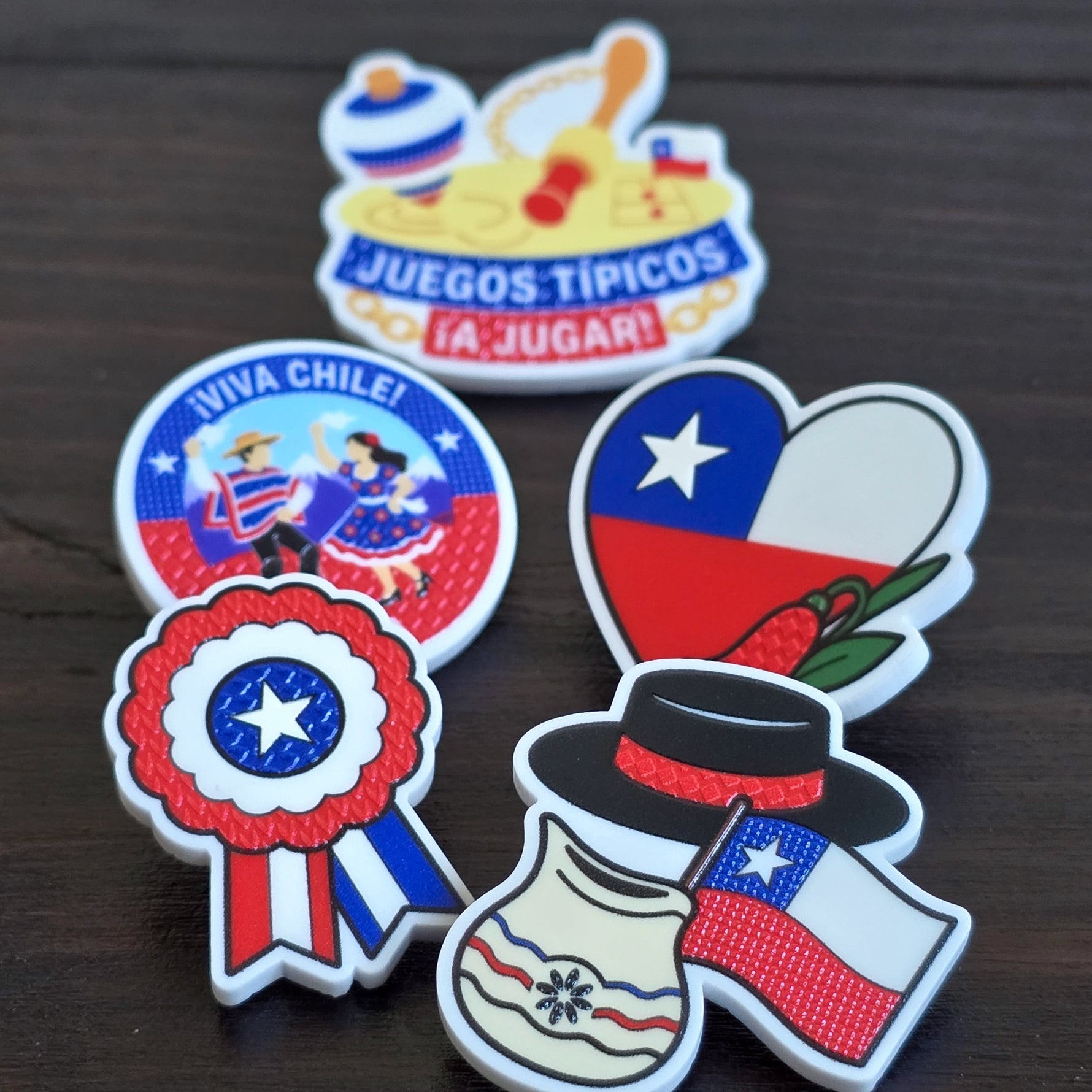Los cinco pines de Fiestas Patrias: escarapela, corazón con copihue, sombrero y jarro de greda, juegos típicos y cueca